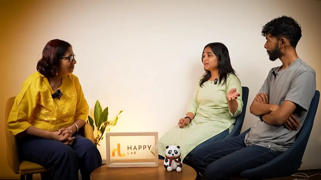 Three people seated in a conversation at Happy Lab